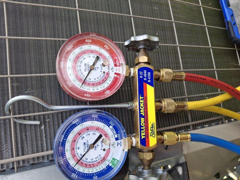 Performed comprehensive cooling system maintenance on residential air conditioning unit located at rear of property. Conducted thorough inspection of condenser coil fins, which showed normal wear consistent with system age, and utilized manifold gauge set to verify refrigerant pressures and system performance across both high and low side circuits. All components operating within manufacturer specifications with no deficiencies noted requiring immediate attention.