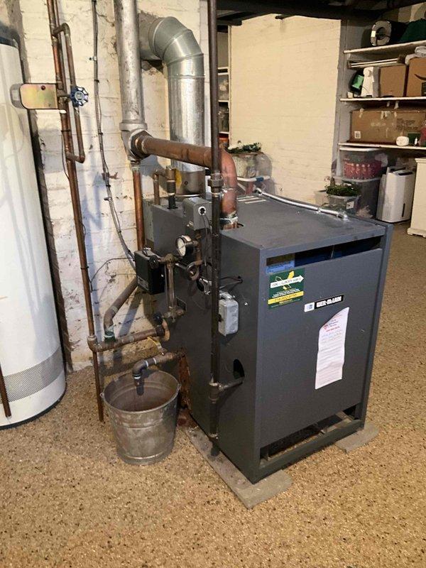 Responded to service call for boiler system not turning on. Upon arrival, inspected dark gray/black boiler unit in basement mechanical room along with associated copper piping, venting, and electrical connections. Customer reported completely black thermostat display, suspecting thermostat failure as root cause. Evaluated thermostat functionality, power supply to boiler system, and overall equipment operation to diagnose no-heat condition and provide estimate for necessary repairs or replacement components.