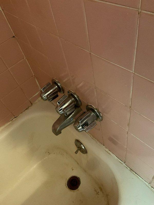 Installed customer-supplied shower fixtures in bathroom with existing pink tile surround and bathtub. Replaced three-handle wall-mounted faucet assembly and tub spout with new chrome fixtures, ensuring proper connections and testing for leaks upon completion.