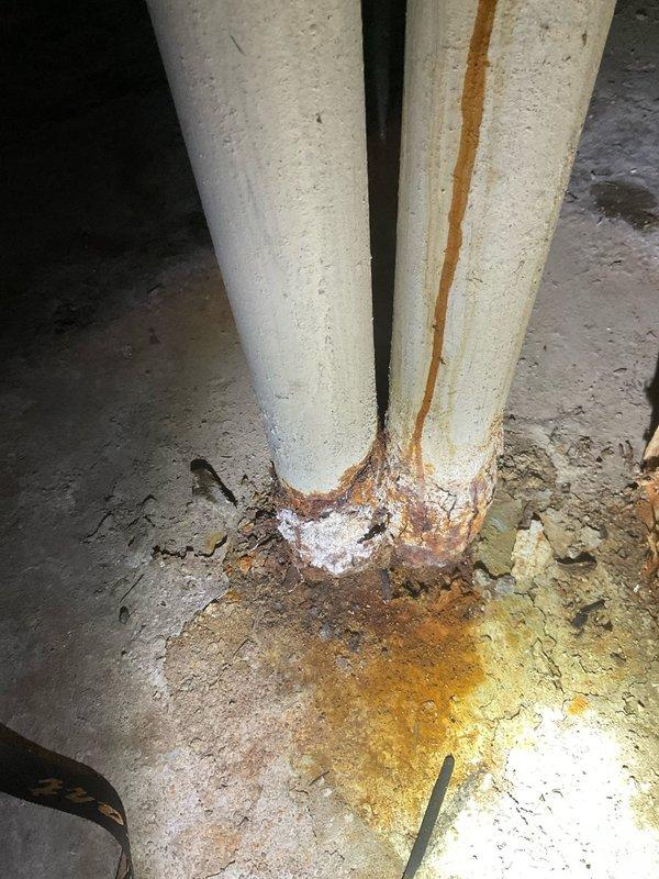 Responded to initial service call for multiple plumbing issues including shower head replacement and leaking pipes throughout the property. Upon arrival, conducted comprehensive inspection of plumbing system to identify all areas requiring immediate attention.

Addressed shower head replacement in bathroom, removing deteriorated fixture and installing new unit to restore proper water flow and eliminate leaking at connection point. Inspected associated supply lines and connections for additional leak sources.

Performed thorough assessment of basement plumbing infrastructure where multiple concerns were identified. Documented extensive corrosion on vertical drain pipes, with significant rust staining evident on pipe surfaces and heavy rust accumulation at floor penetration points. Observed substantial moisture damage and discoloration on concrete floor surrounding pipe bases, indicating active or recent water seepage from compromised pipe joints.

Identified corroded drain pipe in advan