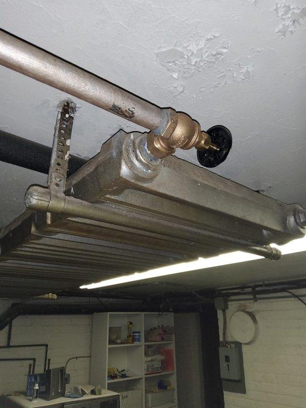 Completed initial service call to assess steam boiler system experiencing moisture damage to surrounding structures and adjacent piping areas. Upon inspection, observed deteriorating ceiling conditions near steam radiator unit with visible water damage, peeling paint, and plaster degradation caused by escaping steam and condensation. Documented existing copper piping configuration, radiator connections, and areas of concern including compromised wall surfaces showing moisture streaking and staining. Discussed remediation options with customer to address steam containment issues and prevent further structural damage to basement utility area.
