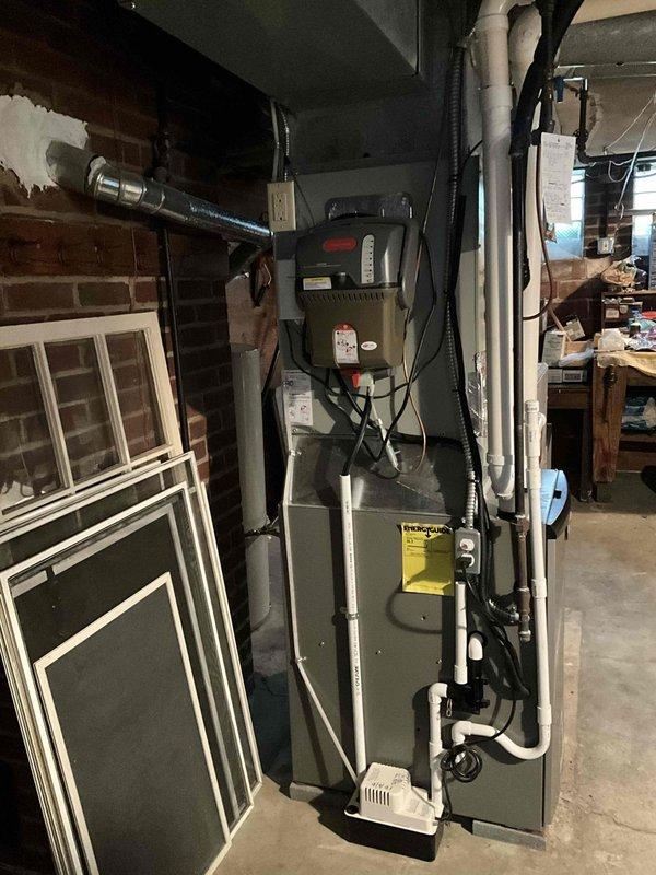 Conducted on-site evaluation of existing HVAC system for replacement estimate. Assessed outdoor condensing unit, a XL 16i model manufactured in October 2009, rated at 230 volts and 24.0 amps. Unit showed age-related wear consistent with 15+ years of operation. Documented indoor furnace system located in basement mechanical room, including associated ductwork, PVC condensate drainage lines, electrical connections, and venting configuration. Photographed both indoor and outdoor equipment to document current system specifications and installation conditions for replacement proposal preparation.