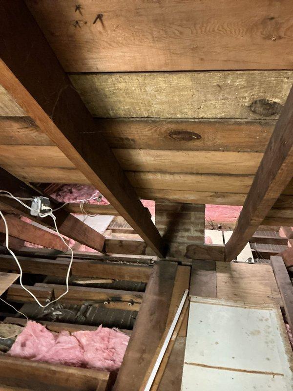 Conducted on-site assessment for mini split air conditioning installation on second floor of residence with hot water heat. Evaluated attic access and structural conditions, documenting exposed ceiling joists, existing insulation, and electrical routing to determine optimal placement for indoor and outdoor units compatible with customer's preference for non-automated controls.