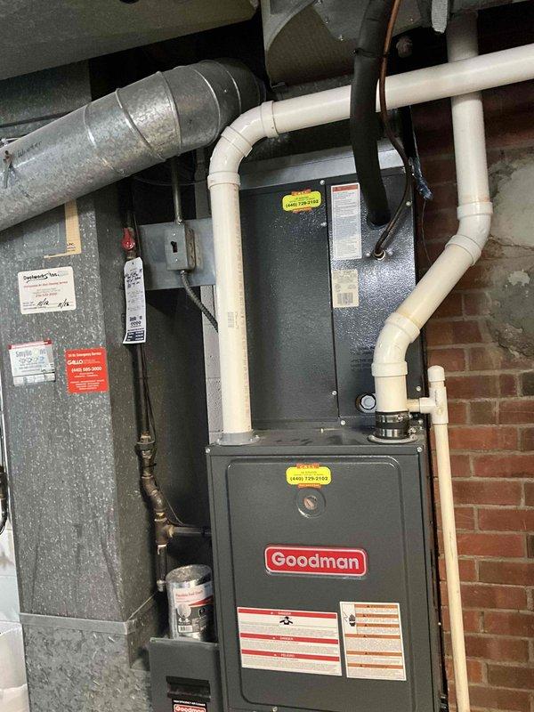 Conducted comprehensive assessment of 14-year-old residential HVAC system to provide replacement estimate. Inspected existing Goodman furnace and air handler unit located in basement mechanical space against exposed brick wall. Evaluated current equipment condition, ductwork configuration, PVC condensate drain lines, electrical connections, and overall system layout. Documented equipment specifications, model information, and installation constraints including confined workspace between masonry walls. Photographed existing system components and utility connections to develop accurate replacement proposal. Provided homeowner with detailed equipment replacement recommendations and scheduling options for complete system changeover.