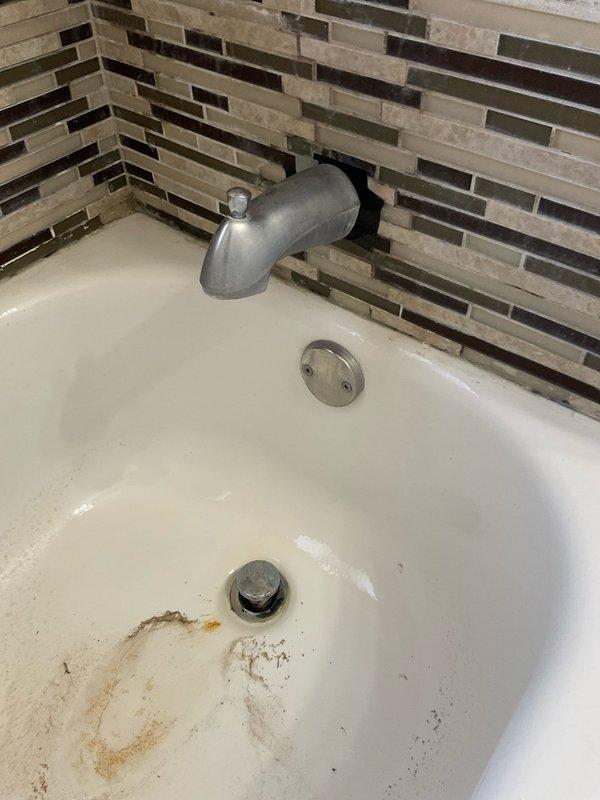 Completed free home plumbing assessment for reported bathroom sink and tub leaks. Upon inspection, identified tub spout installation, drain stopper mechanism, and overflow drain assembly in bathtub with mosaic tile surround. Observed visible staining and discoloration around drain area indicating potential leak issues. Assessed ceiling condition above bathroom, noting moisture-related damage and discoloration around light fixture, consistent with water intrusion from plumbing fixtures. Documented findings with photographs and advised customer of drain replacement options with available discount if replacement becomes necessary.