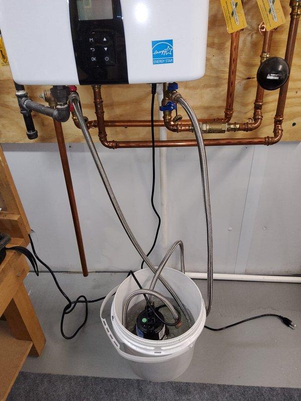 Performed complimentary tankless water heater maintenance flush on Energy Star-rated unit. Utilized circulation pump and bucket system to flush heating elements and heat exchanger, removing mineral buildup and sediment accumulation. Verified proper operation of isolation ball valves on inlet and outlet copper lines, confirmed system pressures, and tested unit functionality post-flush. Addressed discrepancy regarding service plan coverage documentation between client records and company system.