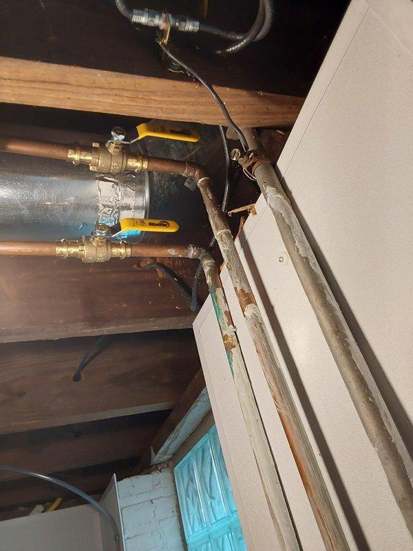 Installed access hole in wall to reach and secure loose bathroom fixture mounted on beadboard paneling. Cut precise opening to access plumbing connections behind wall, properly fastened fixture hardware, and installed access panel cover for future serviceability. Verified all connections for proper operation and inspected for leaks. Work included coordination between bathroom fixture area and attic/crawl space plumbing components where copper supply lines with ball valves connect to existing plumbing infrastructure.