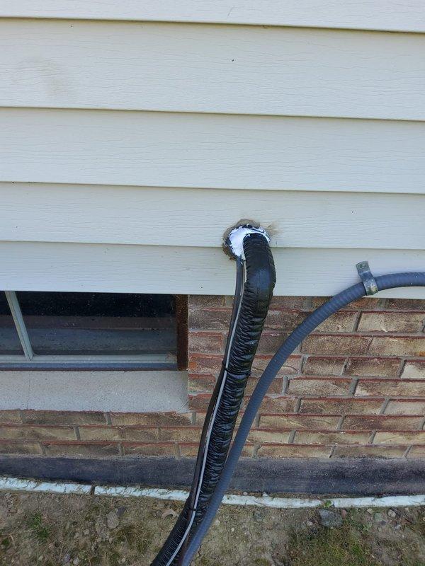 Completed A/C system startup and addressed exterior penetration sealing as identified during inspection. Properly caulked and sealed the wall penetration where refrigerant line set passes through vinyl siding to prevent air and moisture infiltration, ensuring code compliance and system protection.