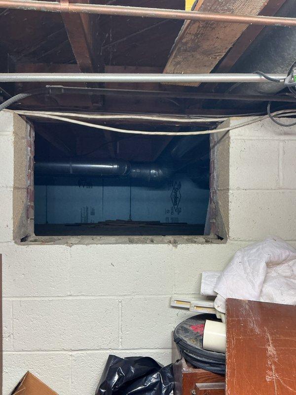 Responded to service call for seasonal air conditioning maintenance on an 11-year-old system that had not been operated yet this season. Upon arrival, accessed HVAC equipment located in basement utility area through wall opening adjacent to air handling unit. Performed comprehensive AC tune-up including system inspection, verification of refrigerant levels, electrical connections check, and operational testing of all components. Confirmed unit functionality and readiness for cooling season operation.