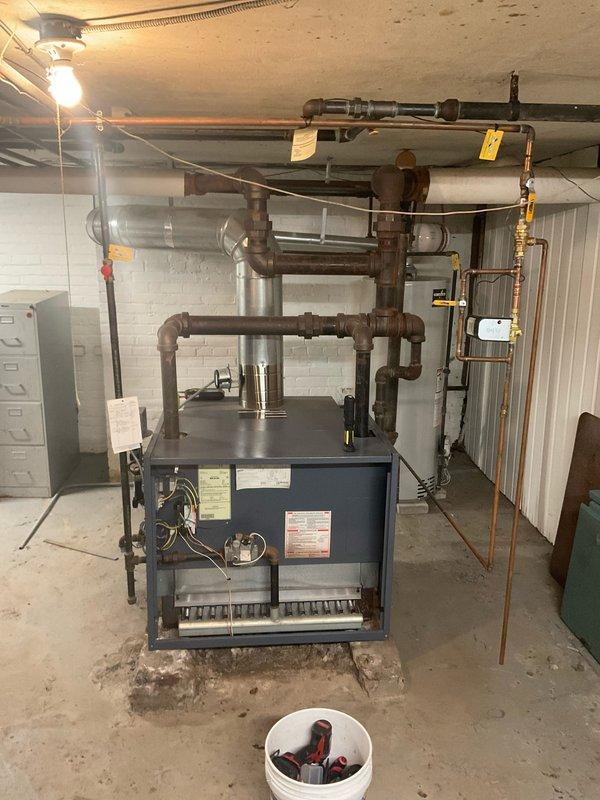Performed comprehensive heating system maintenance on residential boiler unit located in basement mechanical room. Conducted thorough inspection of boiler cabinet, piping configuration, and associated components including expansion tank, copper supply lines, and isolation valves. Utilized combustion analyzer to test system performance, recording flue gas temperature of 351.5°F, oxygen level of 8.92%, carbon monoxide at 0 ppm, and carbon dioxide at 6.82%. All combustion readings within acceptable parameters indicating proper burner operation and heat exchanger efficiency. Visually inspected all pipe connections, fittings, and valves for signs of leaks or corrosion. Verified proper operation of circulator pump and zone valves. Confirmed expansion tank mounting and pre-charge pressure. System operating safely and efficiently with no deficiencies noted.