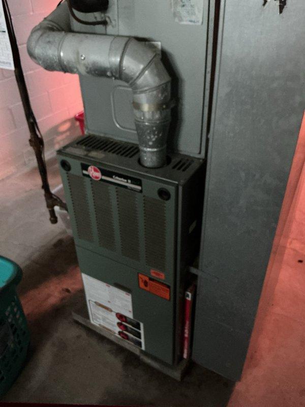 Completed HVAC system replacement estimate for existing Rheem furnace and air handler unit installed in basement utility room. Documented current equipment configuration including ductwork connections and system specifications to provide accurate replacement recommendations for aging system originally installed in 2005.
