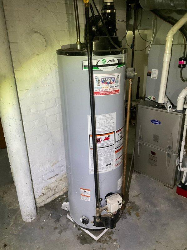 Responded to service call for water heater evaluation with scheduled availability window and advance call notification. Upon arrival, conducted comprehensive assessment of existing A.O. Smith electric tank-style water heater located in basement utility room, which customer reported to be approximately 10 years old. Inspected unit for overall condition, noting manufacturer labels, specifications, and safety warnings intact on exterior surface. Examined top-mounted plumbing connections including black pipe fittings and electrical components for proper installation and signs of wear or deterioration.

Evaluated electrical service by inspecting breaker panel to determine capacity and compatibility for potential tankless electric water heater conversion. Documented existing electrical infrastructure including circuit breaker configuration and available amperage. Photographed current water heater installation and electrical panel for reference and estimate preparation.

Provided customer wit
