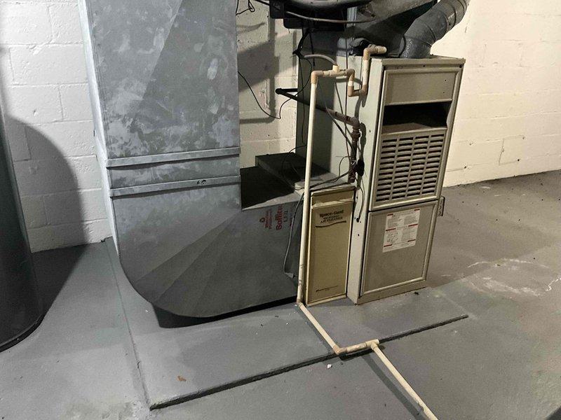 Conducted comprehensive assessment of 30-year-old furnace and air conditioning system for replacement estimate. Documented existing HVAC equipment installation in basement mechanical room, including aging furnace unit with connected ductwork and ventilation systems. Provided detailed evaluation and replacement recommendations for outdated heating and cooling equipment.