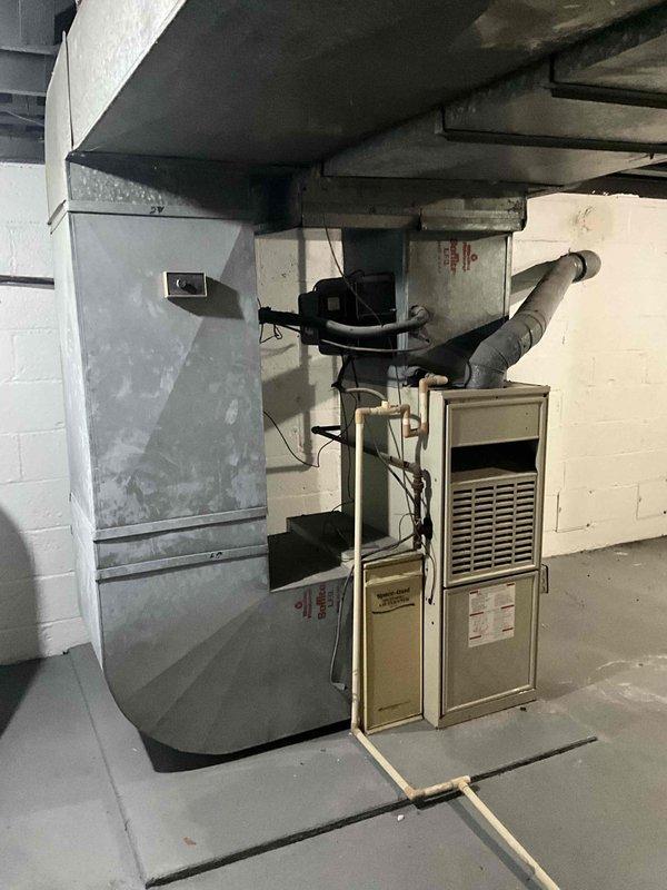 Conducted comprehensive assessment of 30-year-old furnace and air conditioning system for replacement estimate. Documented existing HVAC equipment installation in basement mechanical room, including aging furnace unit with connected ductwork and ventilation systems. Provided detailed evaluation and replacement recommendations for outdated heating and cooling equipment.