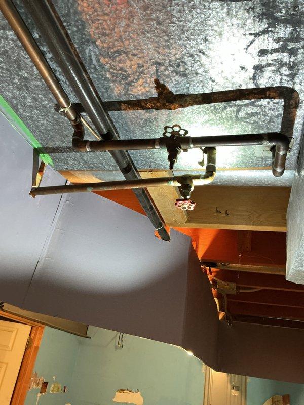 Conducted site assessment for kitchen remodeling estimate with plumbing requirements. Documented extensive water damage to ceiling surfaces showing discoloration, staining, and deterioration requiring remediation prior to remodeling work. Inspected existing copper supply lines, corroded valves, and pipe fittings in affected areas, photographing conditions of plumbing infrastructure, structural framing, and mechanical components to provide accurate scope of work for comprehensive kitchen renovation project.