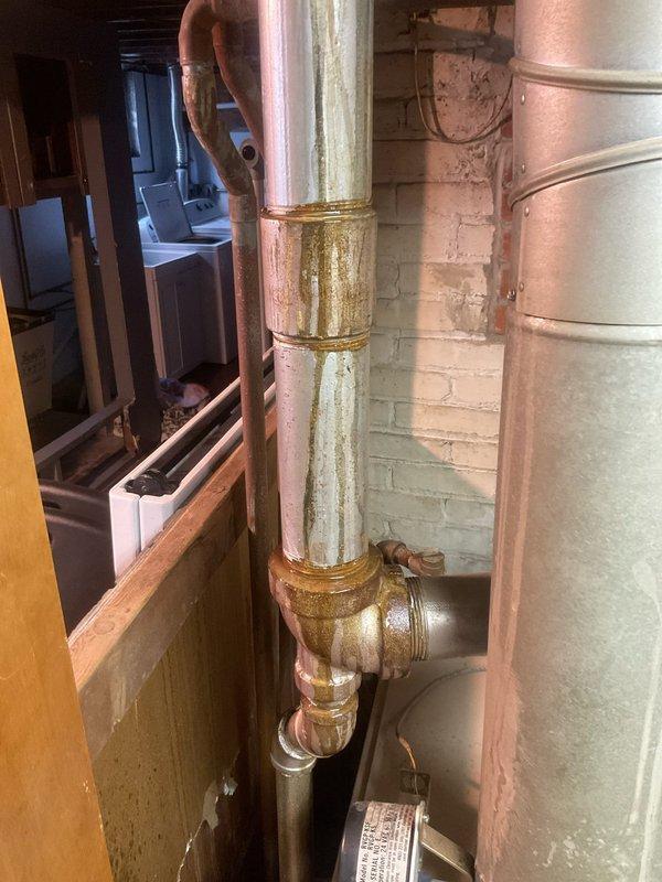 Responded to emergency water leak in century-old residential property. Upon arrival, conducted thorough inspection of basement plumbing system and identified active leak source at corroded copper supply line with severely deteriorated threaded galvanized steel fittings. The affected piping displayed extensive oxidation, greenish-yellow corrosion patterns, and compromised joint integrity consistent with age-related material failure.

Shut off main water supply to prevent further water damage. Removed damaged section of corroded copper pipe and failing galvanized steel coupling assembly. Replaced compromised piping with new copper supply line using proper soldering techniques and installed new brass fittings to ensure watertight connections. All joints were cleaned, fluxed, and soldered to code specifications.

Pressure tested the repaired section to verify system integrity and confirm no additional leaks were present. Restored water service and monitored all connections for proper opera
