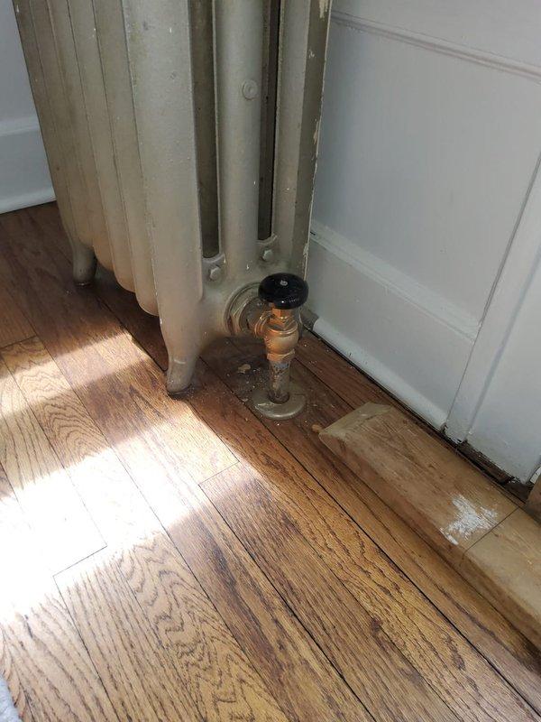 Replaced nine radiator valves throughout the residence as part of a scheduled heating system maintenance project. Work was performed with assistance from another technician to ensure efficient completion. Photos documented pre-existing floor staining near valve locations and confirmed proper installation of new valve assemblies with control knobs at multiple radiator units.