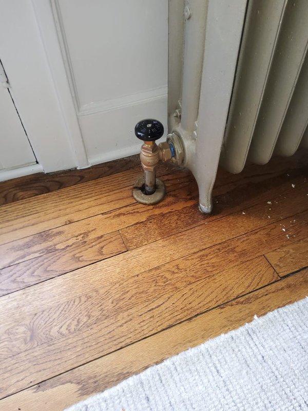 Replaced nine radiator valves throughout the residence as part of a scheduled heating system maintenance project. Work was performed with assistance from another technician to ensure efficient completion. Photos documented pre-existing floor staining near valve locations and confirmed proper installation of new valve assemblies with control knobs at multiple radiator units.
