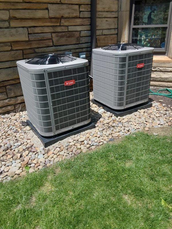 Completed full installation of dual-zone air conditioning system at residential property. Removed existing equipment and installed two complete AC systems in attic space, including outdoor condensing units, indoor air handlers, safety drain pans with wet switches, and programmable thermostats.

Positioned both outdoor condensers on level gravel pad adjacent to exterior stone wall, ensuring proper clearance for airflow and future maintenance access. Mounted units on vibration-dampening pads and completed all refrigerant line connections and electrical hookups per manufacturer specifications. Verified adequate spacing between units for optimal performance.

In attic, installed two air handler units on secondary drain pans with integrated wet switch float sensors to prevent water damage from potential condensate overflow. Configured PVC condensate drainage lines with proper pitch and secured all connections. Connected supply and return ductwork using insulated flexible ducting, ensuring p
