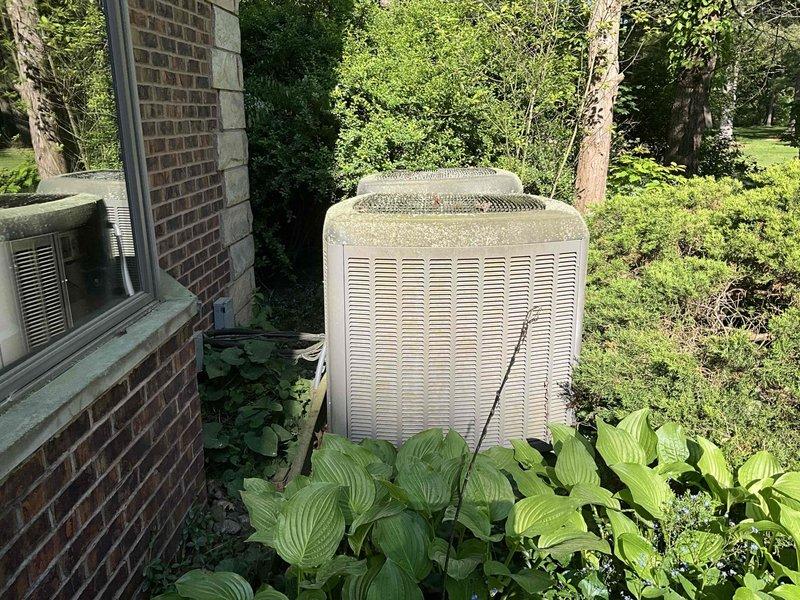 Completed comprehensive estimate for replacement of 20-year-old HVAC system including outdoor air conditioning condenser unit and indoor Lennox furnace with air handler. Assessed existing equipment condition, documented weathered exterior condenser with visible dirt accumulation and discoloration, evaluated basement-installed furnace and air handler with exposed internal components, and photographed all equipment for replacement specifications.