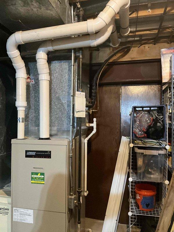 Completed comprehensive estimate for replacement of 20-year-old HVAC system including outdoor air conditioning condenser unit and indoor Lennox furnace with air handler. Assessed existing equipment condition, documented weathered exterior condenser with visible dirt accumulation and discoloration, evaluated basement-installed furnace and air handler with exposed internal components, and photographed all equipment for replacement specifications.