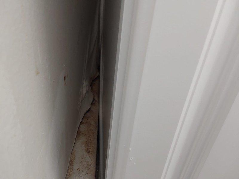 Performed radiator service and inspection in residential space. Updated lockbox access code to FAL per customer request via chat communication. Assessed traditional cast iron column-style radiator installation with approximately 10-11 sections positioned against interior wall. Verified proper valve and pipe connections at base of unit. Documented existing conditions including exposed brick wall adjacent to heating system and modern flooring installation. Noted minor surface wear and paint residue on radiator exterior consistent with age of equipment. Inspected window frame components and identified moisture-related deterioration with rust staining and finish degradation requiring monitoring. System operational upon completion of service call.