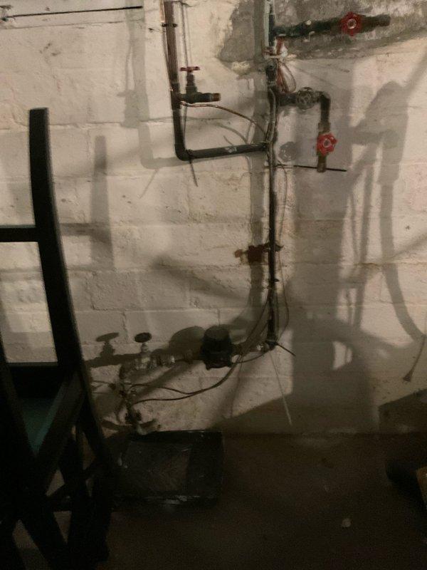 Responded to service call regarding rust-colored water appearing from multiple faucets throughout the residence. Conducted thorough inspection of water heater to determine if it was the source of contamination. Upon examination, confirmed water heater was functioning properly and ruled out as the primary cause of discoloration. Performed comprehensive plumbing system assessment, inspecting supply lines, shut-off valves, and fixture connections visible in bathroom and basement utility areas. Documented existing plumbing infrastructure including copper and galvanized pipe configurations with photographic evidence for reference.