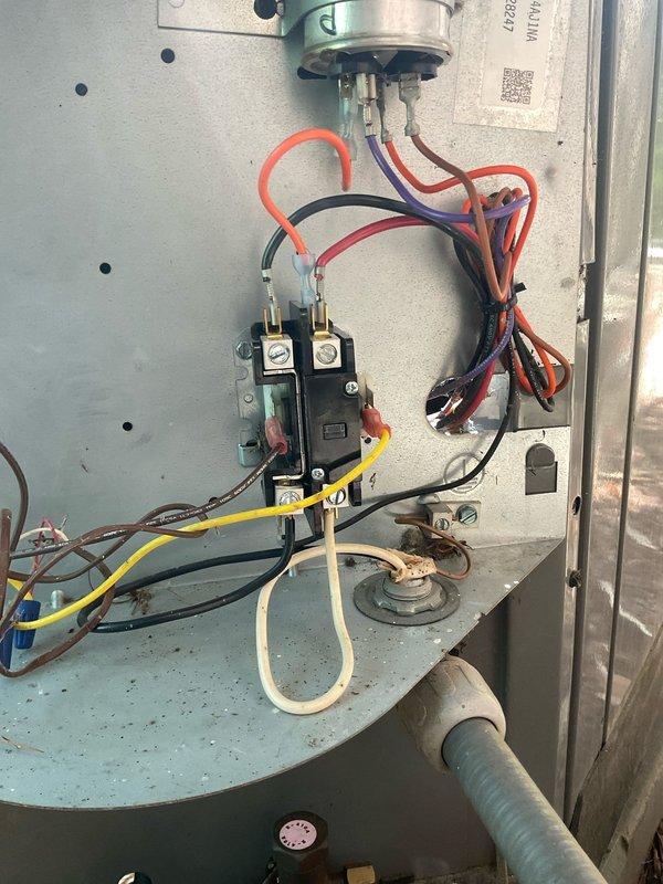# HVAC Service Call - No Heat Condition

Responded to no heat service call for furnace system. Customer reported furnace trouble with age unknown; unit had been serviced the previous week. Contacted customer en route to confirm appointment and availability.

Upon arrival, performed system evaluation and visual inspection of furnace components. Accessed electrical control panel and examined internal wiring and connections. Inspected contactor/relay assembly with multiple wire terminations including power and control circuit wiring. Verified all wire connections were secure at terminal points.

Examined capacitor component and associated wiring harness. Noted accumulated debris and organic matter on control panel mounting surface, indicating need for routine maintenance cleaning. Documented electrical panel configuration showing standard color-coded wiring arrangement with red, black, yellow, purple, orange, and white conductors.

Checked all electrical connections at contactor terminal 
