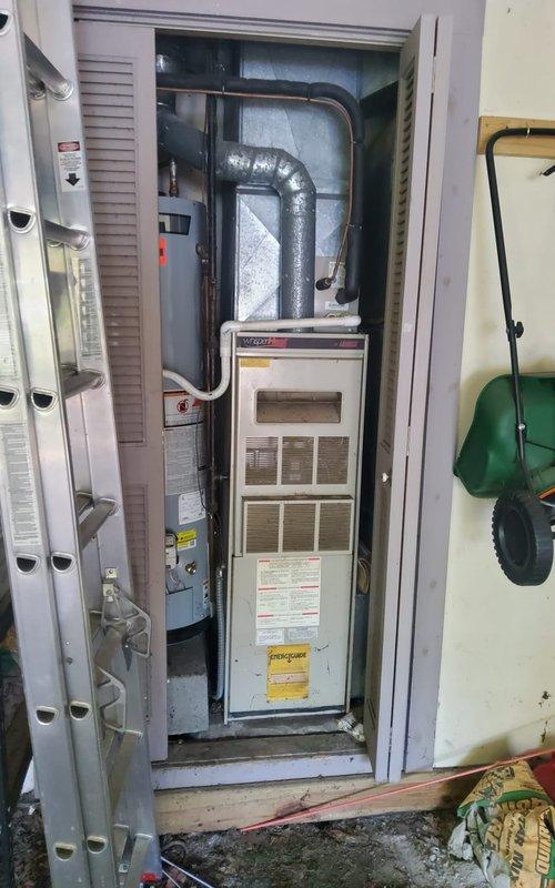 Responded to service call for non-operational fan on 30-year-old heating and cooling system. Upon arrival, inspected Lennox outdoor condensing unit (Model HS29-024-2P) and indoor furnace installation. Documented existing equipment condition showing significant age-related wear, outdoor weathering, and accumulated debris on exterior components. Assessed HVAC system configuration including vertical furnace unit with flexible ductwork connections in utility closet alongside water heater. Photographed equipment specifications, serial numbers, and overall system layout for service records. Given the advanced age of the equipment and failed fan component, provided assessment and recommendations for repair or replacement options to restore heating and cooling functionality.