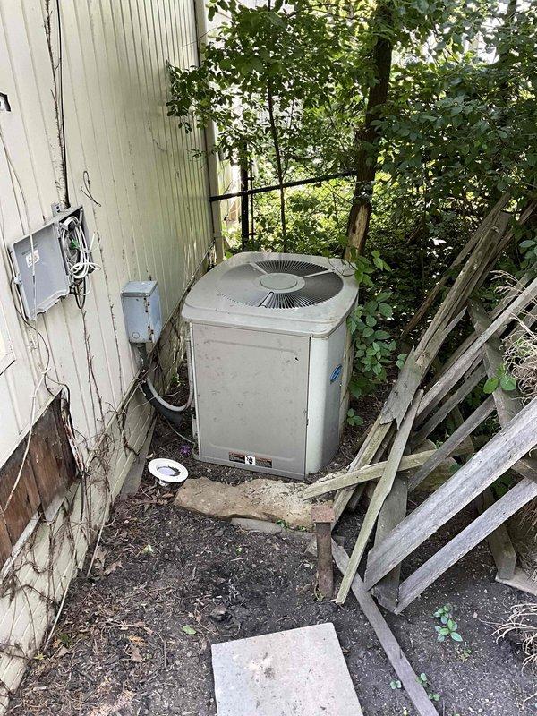 Responded to no cooling complaint on 20+ year old air conditioning system. Upon arrival, inspected outdoor condensing unit which showed significant age and weathering with accumulated dirt and debris. Unit was positioned against building exterior in overgrown area with poor maintenance access. Evaluated indoor air handler equipment in basement mechanical room, noting aging coil assembly and refrigerant piping configuration. Due to system age exceeding expected service life and complete cooling failure, provided comprehensive estimate for full HVAC system replacement including new outdoor condensing unit and indoor air handler with associated refrigerant lines, electrical connections, and condensate drainage components.