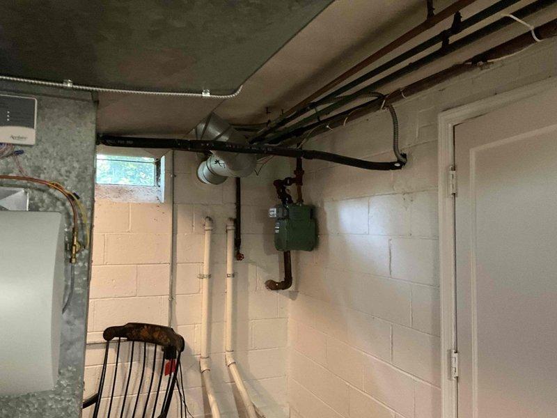 Responded to no cooling complaint on 20+ year old air conditioning system. Upon arrival, inspected outdoor condensing unit which showed significant age and weathering with accumulated dirt and debris. Unit was positioned against building exterior in overgrown area with poor maintenance access. Evaluated indoor air handler equipment in basement mechanical room, noting aging coil assembly and refrigerant piping configuration. Due to system age exceeding expected service life and complete cooling failure, provided comprehensive estimate for full HVAC system replacement including new outdoor condensing unit and indoor air handler with associated refrigerant lines, electrical connections, and condensate drainage components.