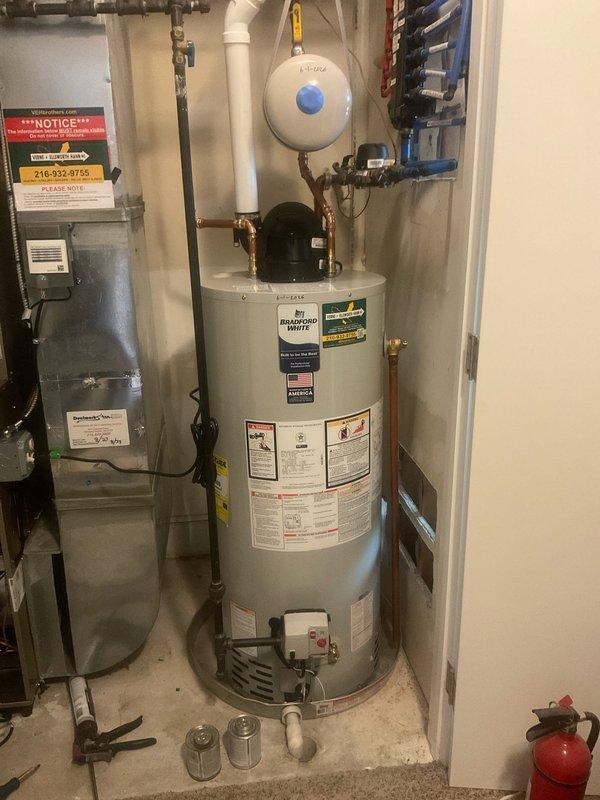 Installed a Bradford White RG1PV40S6N 40-gallon natural gas power vent water heater with 40,000 BTU/hr heating capacity and 43 gph recovery rate. Replaced the existing expansion tank with a new unit, properly mounted to the wall and connected via copper piping to the water heater system. All brass fittings, valves, and connections were secured to ensure proper operation of both the water heater and expansion tank within the residential mechanical system.