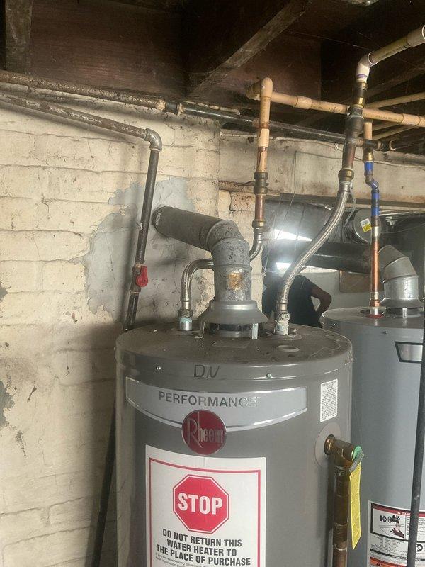 Performed warranty assessment and documentation of failed Rheem D/V Performance tanked water heater in residential basement utility room. Conducted thorough inspection of unit showing signs of base leakage with visible moisture pooling on concrete floor surrounding water heater. Photographed existing installation including all plumbing connections, copper supply lines with brass fittings, blue-handled isolation valve, and associated ductwork. Documented unit model information and warning labels for warranty claim processing. Coordinated findings with property owner regarding Rheem manufacturer warranty coverage and replacement options. Provided detailed photographic evidence of equipment condition and installation configuration. Secured property using existing lockbox access system upon completion of assessment.