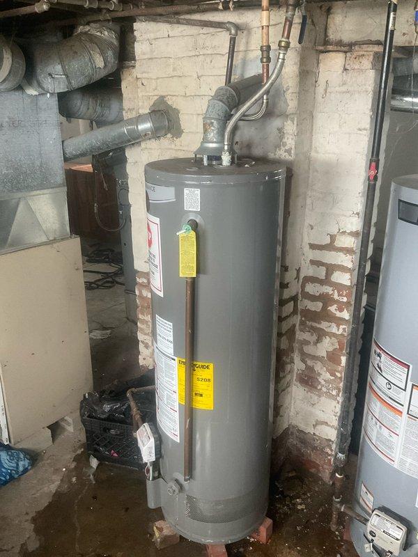 Performed warranty assessment and documentation of failed Rheem D/V Performance tanked water heater in residential basement utility room. Conducted thorough inspection of unit showing signs of base leakage with visible moisture pooling on concrete floor surrounding water heater. Photographed existing installation including all plumbing connections, copper supply lines with brass fittings, blue-handled isolation valve, and associated ductwork. Documented unit model information and warning labels for warranty claim processing. Coordinated findings with property owner regarding Rheem manufacturer warranty coverage and replacement options. Provided detailed photographic evidence of equipment condition and installation configuration. Secured property using existing lockbox access system upon completion of assessment.