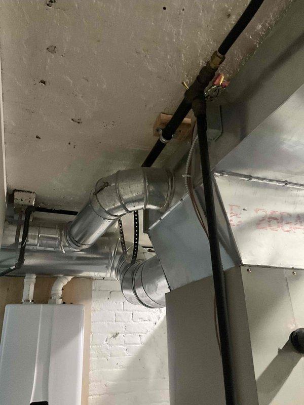 Conducted ductwork estimate and inspection of existing HVAC system in basement utility space. Evaluated rectangular sheet metal ductwork installation, including horizontal runs and angled transitions with proper metal strap support systems. Assessment identified potentially undersized ductwork that may be restricting airflow capacity and reducing system efficiency. Documented current ductwork configuration, support mechanisms, and connection points with photographic evidence for estimate preparation.