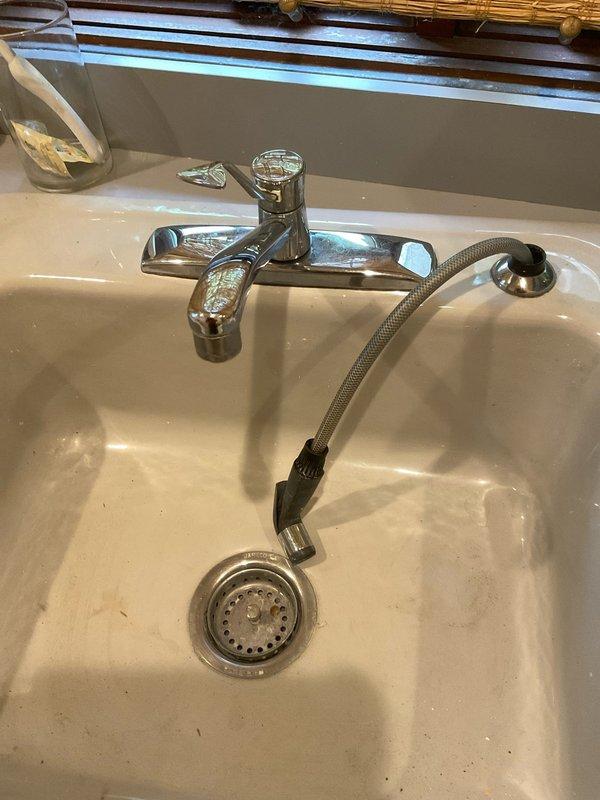 Returned to property to complete installation of customer-supplied kitchen faucet and pull-out spray assembly. Successfully installed single-handle chrome faucet with braided supply lines, connected P-trap drain assembly, and tested all connections for proper operation and leak-free performance.