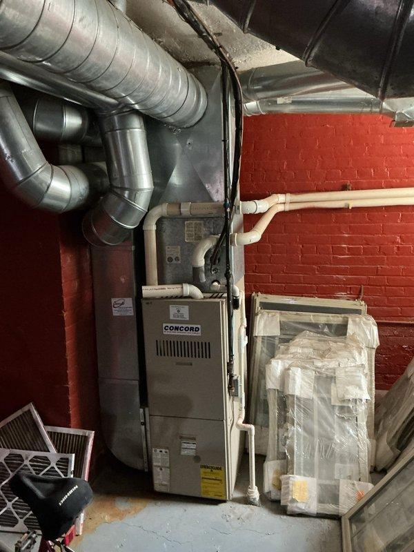 Completed HVAC estimate for unit #9 replacement at commercial property. Assessed existing Concord furnace system in basement mechanical room with connected ductwork network and evaluated rooftop air conditioning condenser units requiring replacement. Documented current equipment conditions, photographed existing installations including basement heating system with extensive metal ductwork and rooftop commercial AC units, and provided replacement recommendations for aging HVAC equipment.