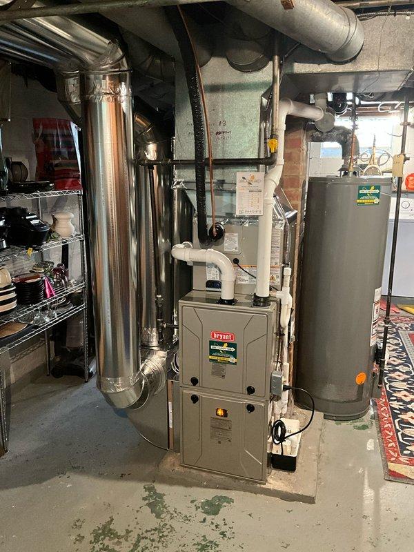 Completed full HVAC system installation including new Bryant furnace in basement mechanical room and outdoor air conditioning condenser unit. Installed condenser on plastic pad adjacent to building exterior with proper clearances, connected refrigerant lines, and established electrical service. Inside mechanical room, positioned furnace unit with vertical supply ductwork extending to distribution system and integrated return air connections to tie back existing returns. Tested system operation, verified proper airflow, checked refrigerant charge, and confirmed all safety controls functioning correctly.