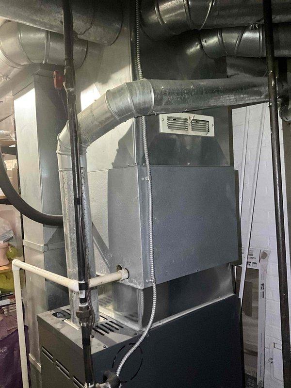Performed complete HVAC system replacement estimate for a 24-year-old system experiencing no cooling condition. Evaluated existing indoor furnace unit with attached air handler located in basement utility area, noting standard ductwork configuration with metal supply trunks and flexible branch connections. Assessed outdoor condensing unit positioned on exterior wall with landscape surroundings, confirming age-related deterioration and system failure. Documented both indoor and outdoor equipment conditions through photographic evidence to support replacement recommendation due to system age exceeding expected service life and current operational failure.