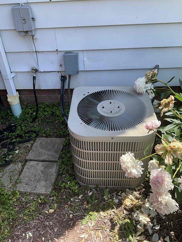 Performed complete HVAC system replacement estimate for a 24-year-old system experiencing no cooling condition. Evaluated existing indoor furnace unit with attached air handler located in basement utility area, noting standard ductwork configuration with metal supply trunks and flexible branch connections. Assessed outdoor condensing unit positioned on exterior wall with landscape surroundings, confirming age-related deterioration and system failure. Documented both indoor and outdoor equipment conditions through photographic evidence to support replacement recommendation due to system age exceeding expected service life and current operational failure.