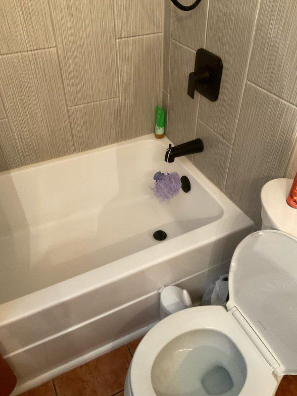 Responded to service call for leaky toilet in 1963-built residence. Upon arrival, conducted thorough inspection of bathroom plumbing fixtures and identified source of water leak at toilet base. Assessed wax ring seal integrity and flange connection, finding deterioration consistent with age of home and fixture. Shut off water supply at angle stop valve and drained toilet tank and bowl completely. Removed toilet mounting bolts and carefully lifted fixture to access flange and existing wax ring. Cleaned flange surface and removed old wax ring residue from both toilet base and floor flange. Inspected closet flange for cracks or damage, confirmed structural integrity adequate for reinstallation. Installed new wax ring with proper alignment and repositioned toilet onto flange, ensuring even seating. Secured toilet with new brass mounting bolts and tightened evenly to manufacturer specifications to prevent rocking or future seal compromise. Reconnected water supply line at tank fill valve an