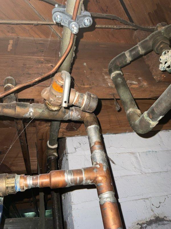 Performed comprehensive plumbing inspection of water heater system, focusing on expansion tank and pressure/temperature relief valve. Evaluated existing plumbing configuration including copper supply lines, connection fittings, and safety valve operation. Documented current condition of water heater assembly, associated piping infrastructure, and proper installation of thermal expansion components to ensure system compliance and safe operation.