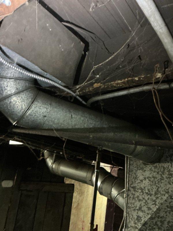 Completed on-site ductwork assessment for estimate purposes. Inspection revealed galvanized metal supply ductwork in basement/crawl space with significant corrosion and rust deterioration on lower sections of vertical duct run, indicating moisture intrusion and metal degradation requiring replacement. Documented existing HVAC distribution system configuration including rectangular trunk lines and cylindrical branch ducts. Photographed compromised ductwork sections showing rust perforation and structural compromise at connection points. Provided comprehensive evaluation of ductwork condition to determine scope of repair versus replacement recommendations for customer decision.