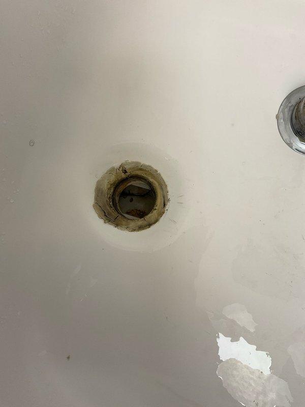 Responded to water leak complaint originating from bathtub drain in 50+ year old home. Upon arrival, coordinated entry access and inspected bathtub fixture and drain assembly on main level. Observed aged drain with significant staining and buildup around rim indicating long-term moisture issues. Proceeded to basement to locate source of active leak. Identified compromised drain piping and fitting assembly beneath tub location accessed through wooden subfloor cutout. Found deteriorated drain connection with visible water damage to surrounding wood framing. Documented conditions with photographs showing bathtub drain condition and basement piping configuration including PVC drain line and mounting bracket assembly. Leak confirmed to activate when tub water is running, consistent with failed drain seal or compromised pipe connection at tub waste assembly.
