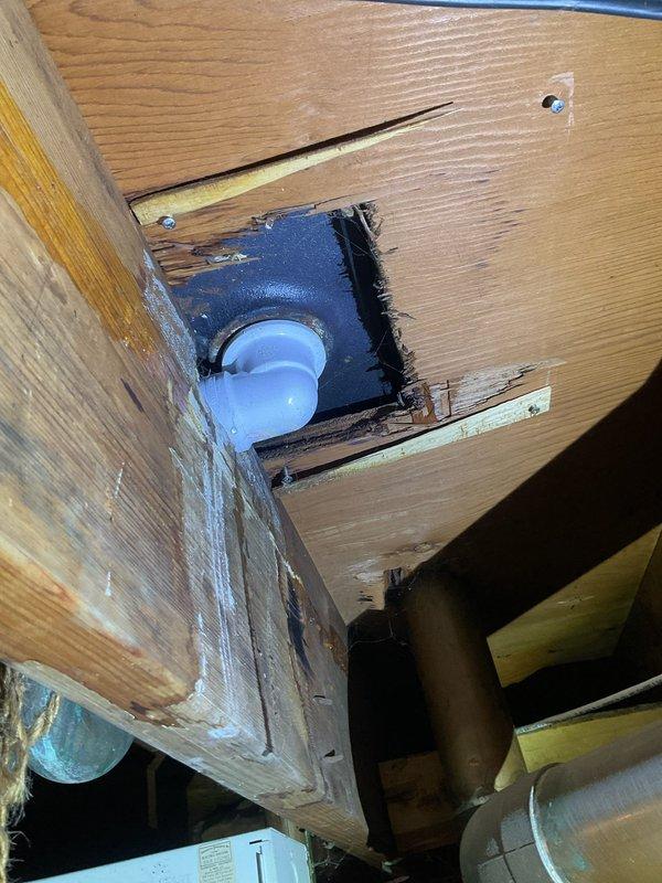Responded to water leak complaint originating from bathtub drain in 50+ year old home. Upon arrival, coordinated entry access and inspected bathtub fixture and drain assembly on main level. Observed aged drain with significant staining and buildup around rim indicating long-term moisture issues. Proceeded to basement to locate source of active leak. Identified compromised drain piping and fitting assembly beneath tub location accessed through wooden subfloor cutout. Found deteriorated drain connection with visible water damage to surrounding wood framing. Documented conditions with photographs showing bathtub drain condition and basement piping configuration including PVC drain line and mounting bracket assembly. Leak confirmed to activate when tub water is running, consistent with failed drain seal or compromised pipe connection at tub waste assembly.