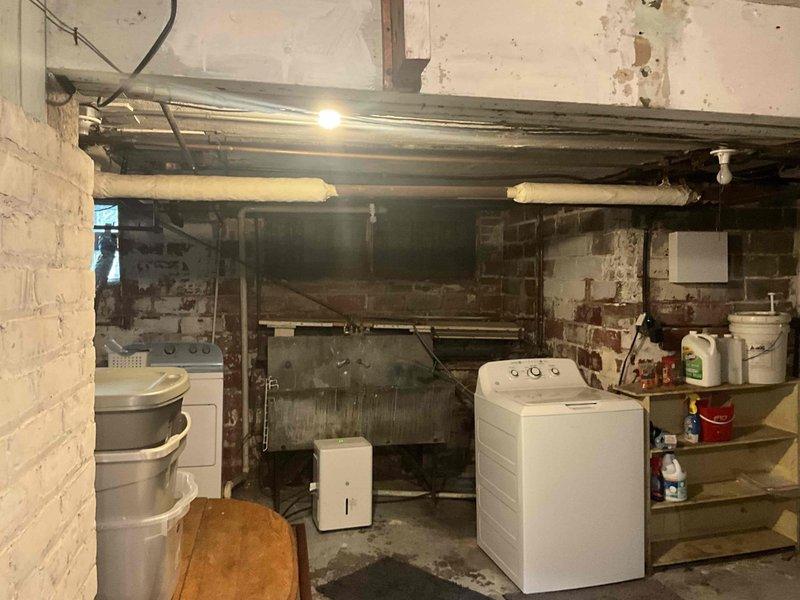 Conducted on-site assessment for conversion from existing steam heating system to forced air HVAC system. Evaluated basement utility area and crawlspace conditions, documenting aged infrastructure including deteriorated brick masonry with moisture damage, exposed plumbing, and existing support structures to determine equipment placement requirements and ductwork routing for proposed forced air installation.