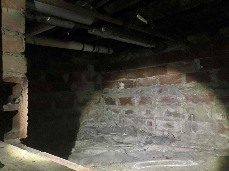 Conducted on-site assessment for conversion from existing steam heating system to forced air HVAC system. Evaluated basement utility area and crawlspace conditions, documenting aged infrastructure including deteriorated brick masonry with moisture damage, exposed plumbing, and existing support structures to determine equipment placement requirements and ductwork routing for proposed forced air installation.
