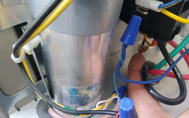 Responded to no-cooling call on a one-year-old residential air conditioning system. Upon inspection, diagnosed a failed dual-run capacitor preventing compressor and condenser fan operation. Replaced defective capacitor with proper 40/5 MFD unit, verified all electrical connections, and tested system for proper operation with normal cooling restored.