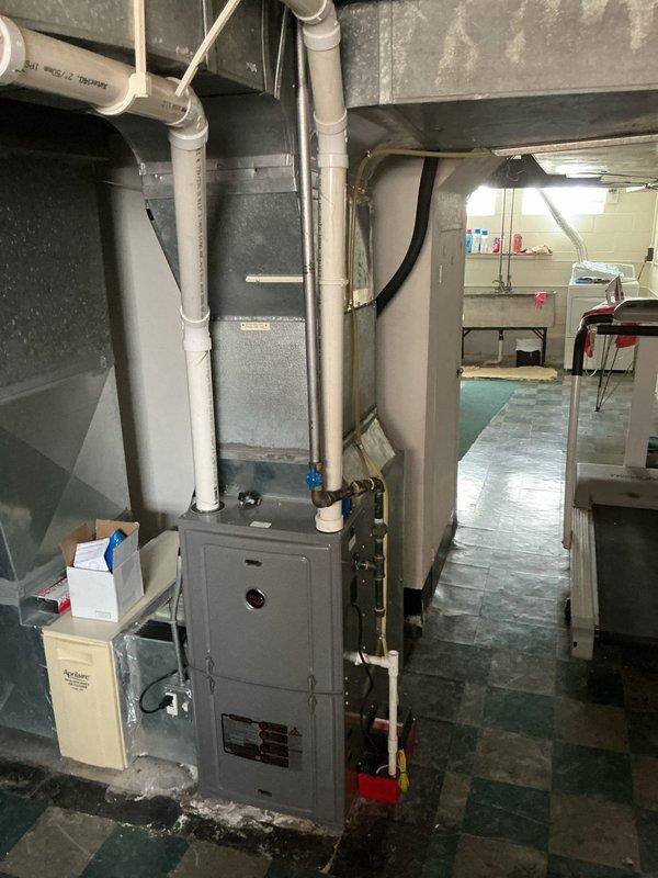 Performed HVAC system evaluation for air conditioning tune-up at residential property with equipment of unknown age. Upon inspection of the basement mechanical room, assessed existing furnace, ductwork, humidification system, and associated refrigerant lines. Documentation captured current system configuration including gas line routing, condensate drainage piping, and electrical connections to establish baseline for replacement estimate preparation.
