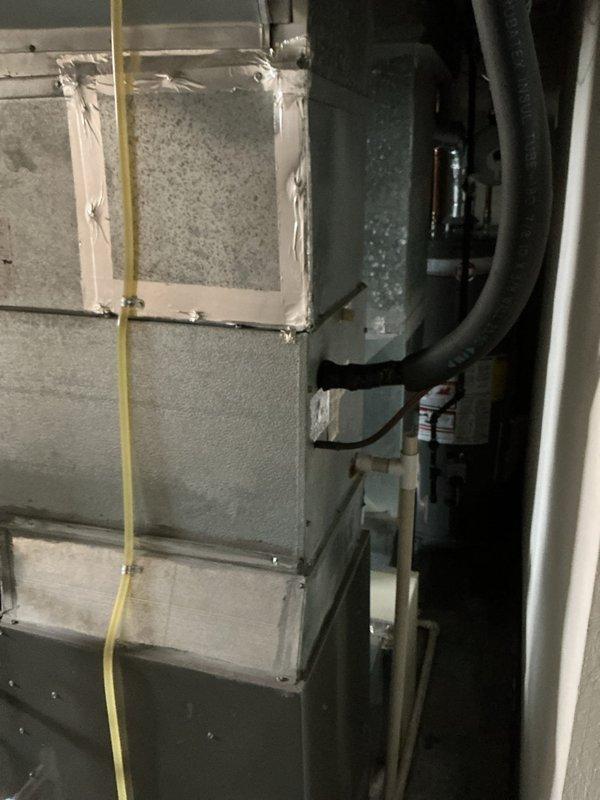 Performed HVAC system evaluation for air conditioning tune-up at residential property with equipment of unknown age. Upon inspection of the basement mechanical room, assessed existing furnace, ductwork, humidification system, and associated refrigerant lines. Documentation captured current system configuration including gas line routing, condensate drainage piping, and electrical connections to establish baseline for replacement estimate preparation.